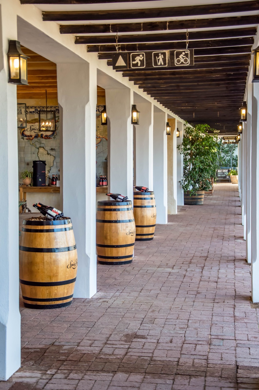 Winery tasting room walkway with barrels, where expense tracking by location matters